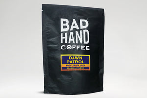 Bad Hand Coffee - Two fifty gramme postal bag of Dawn Patrol, a seasonal blend - taste notes: bright, fruity, juicy. Hand roasted fresh to order. Available as whole bean or ground to your brew method. These bags are 100% paper and home compostable.